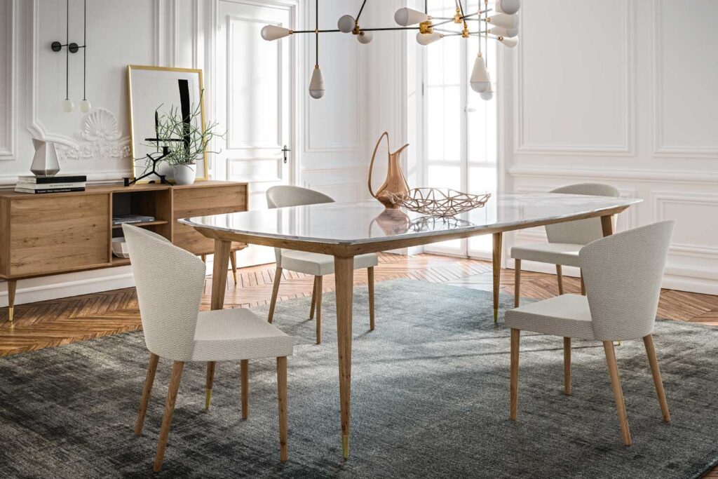 Tavolo in legno massello di design stile art déco con puntali in ottone in un salotto elegante e luminoso.
